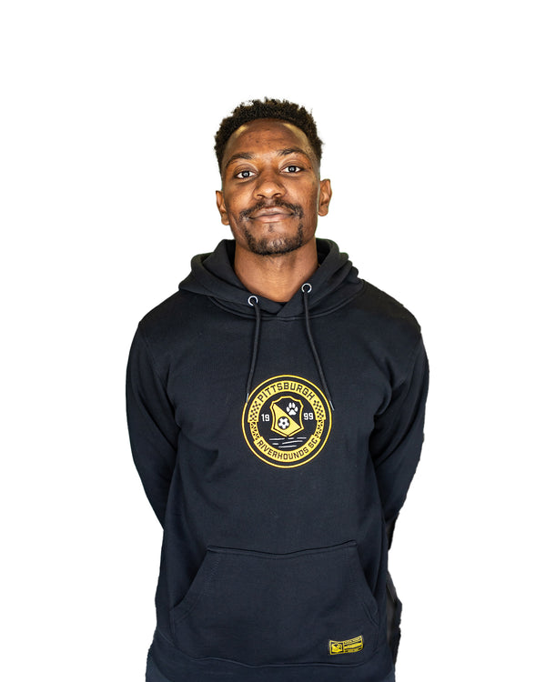 Man wearing a black hoodie with a yellow embroidered logo on a white background